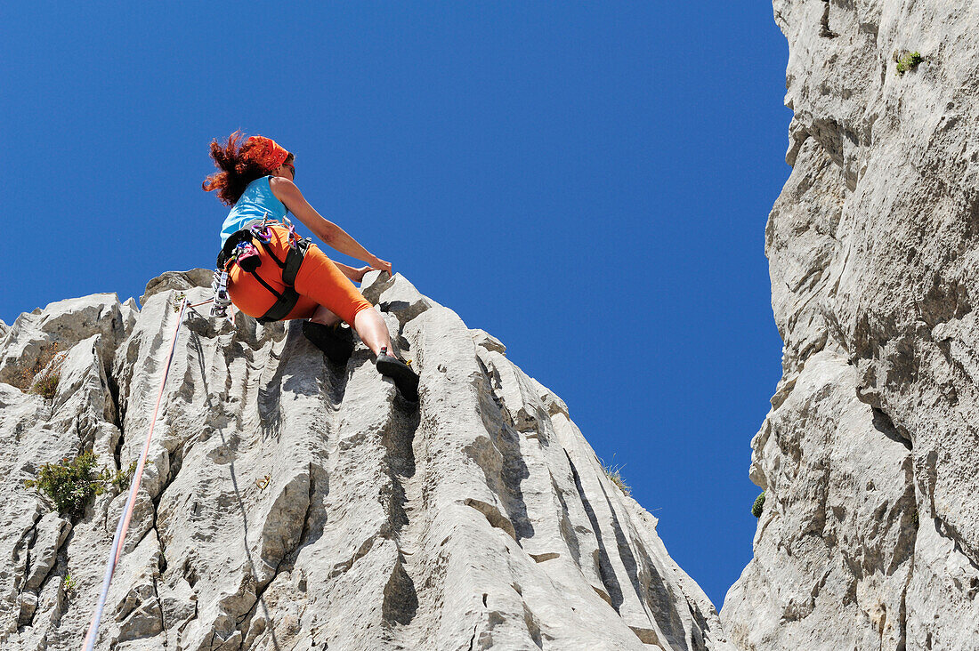 Frau klettert an Felswand, nahe Rifugio Rossi, Pania della Croce, Toskana, Italien
