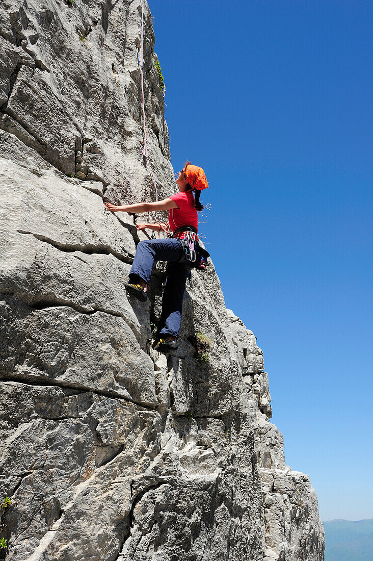 Frau klettert an Felswand, nahe Rifugio Rossi, Pania della Croce, Toskana, Italien