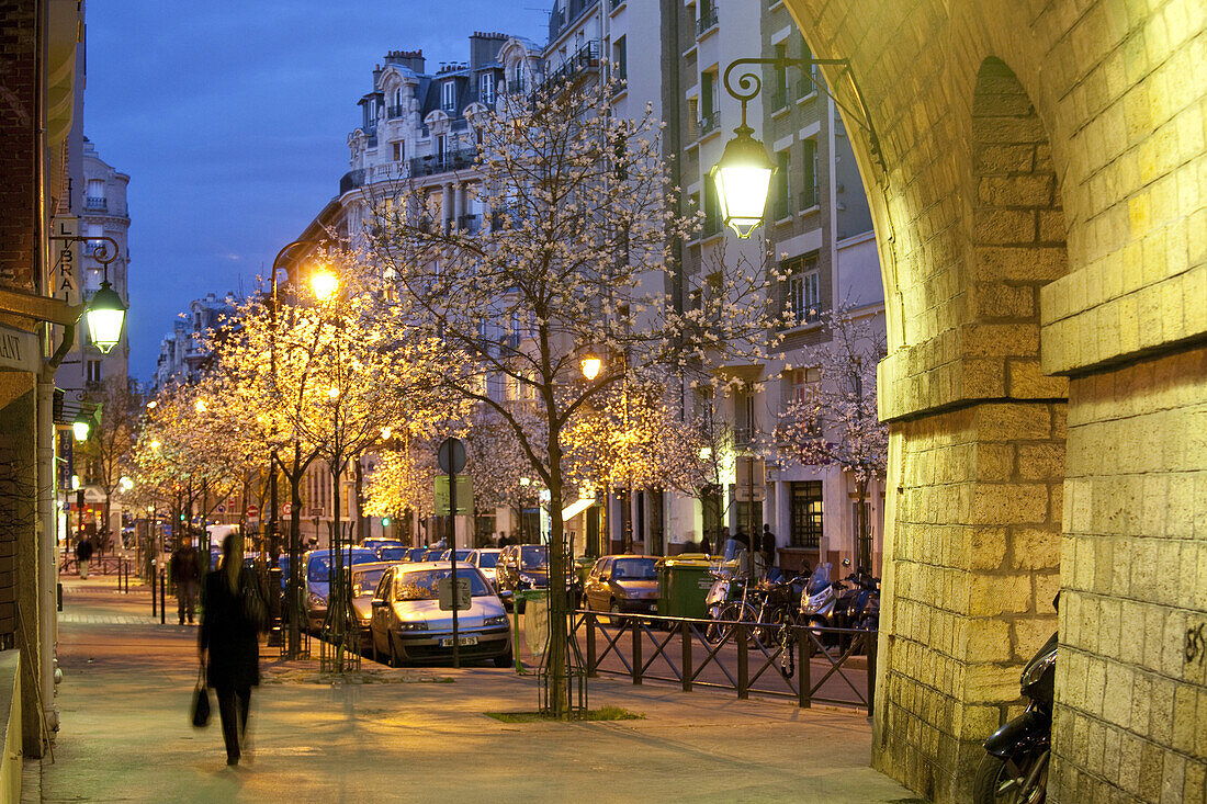 Menschen und beleuchtete Bäume am Viaduc des Arts am Abend, Paris, Frankreich, Europa