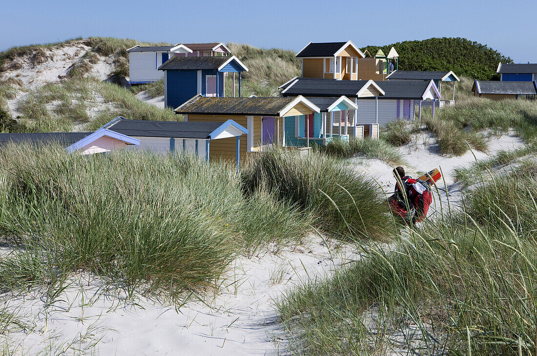 Surfer zwischen Strandhäuschen am Strand von Skanör, Skanör, Schonen, Südschweden, Schweden