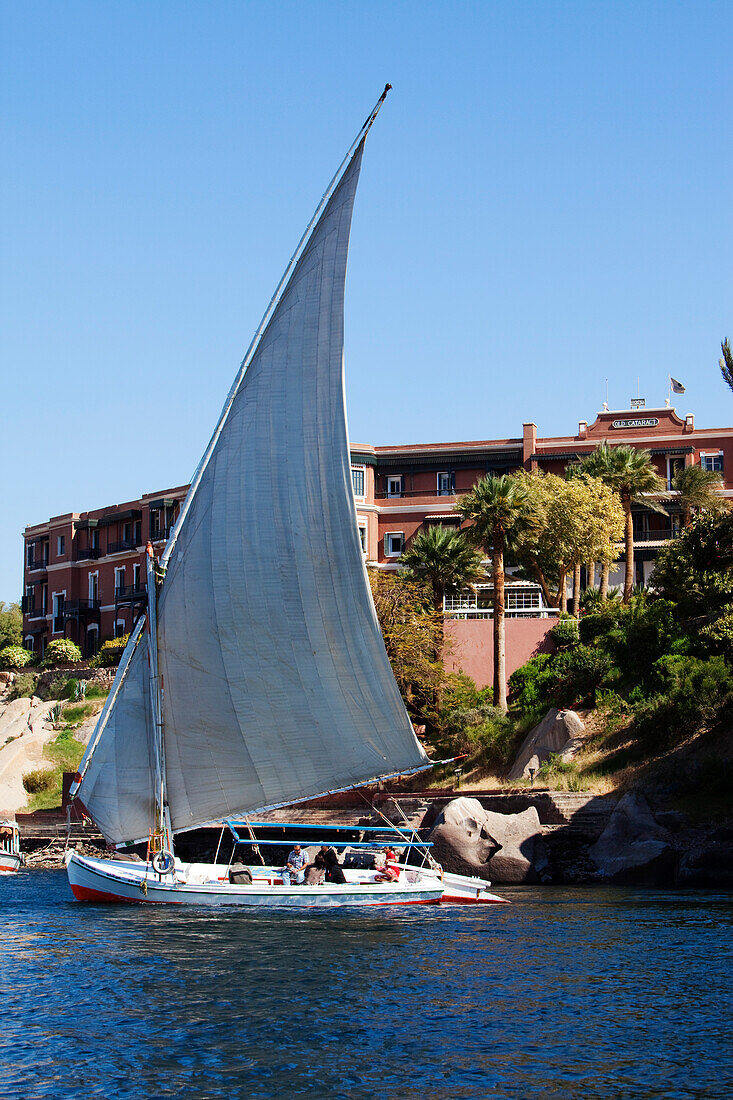 Felucca on the river Nile, the Old Cataract Hotel in the background, Aswan, Egypt, Africa