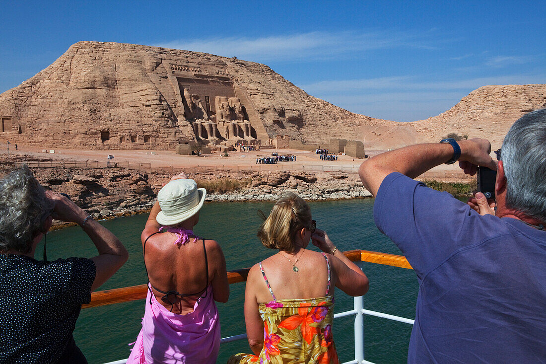 Touristen auf einem Schiff fotografieren den Großen Tempel Ramses II., Abu Simbel, Ägypten, Afrika