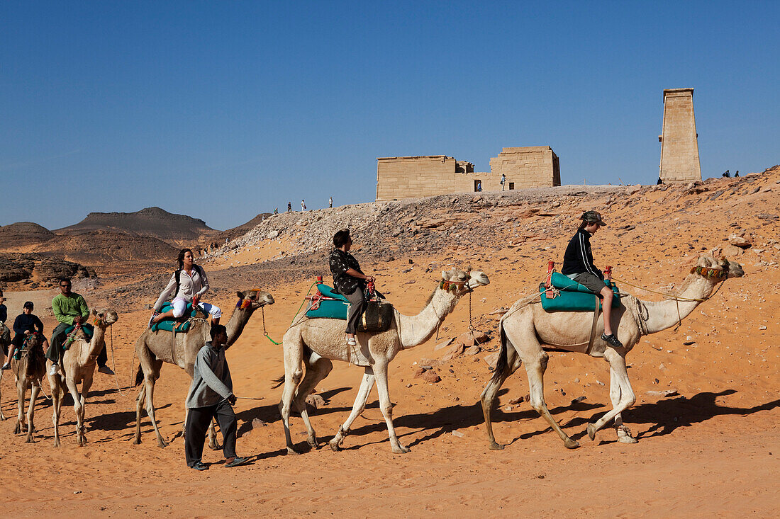 Tourists riding camels in front of the Temple of Dakka, Lake Nasser, Egypt, Africa