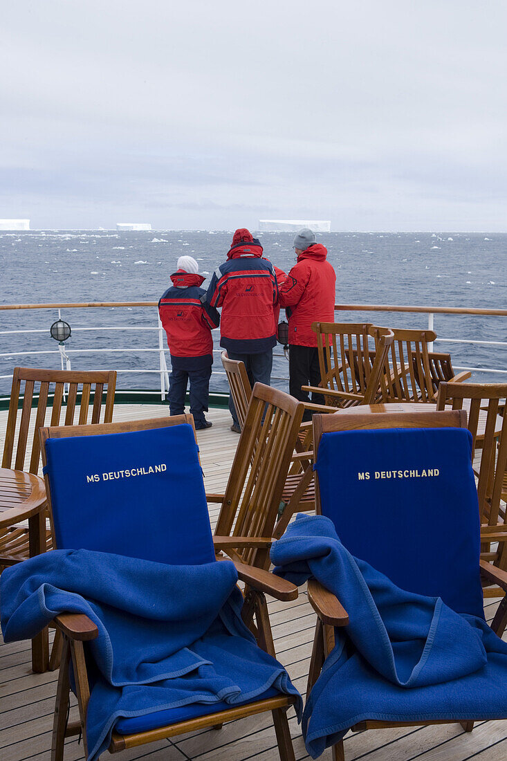People on deck of cruiseship MS Deutschland (Deilmann Cruises) looking at antarctic icebergs, South Shetland Islands, Antarctica
