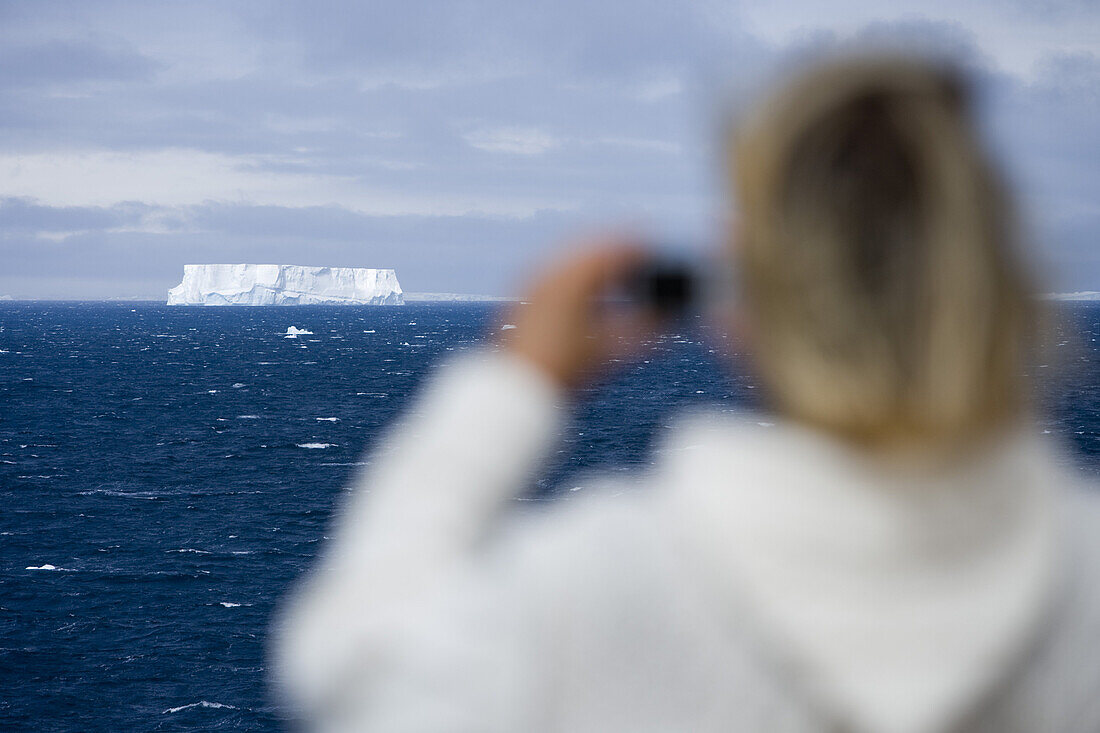 Woman photographing Antarctic iceberg aboard Cruiseship MS Deutschland (Deilmann Cruises), South Shetland Islands, Antarctica