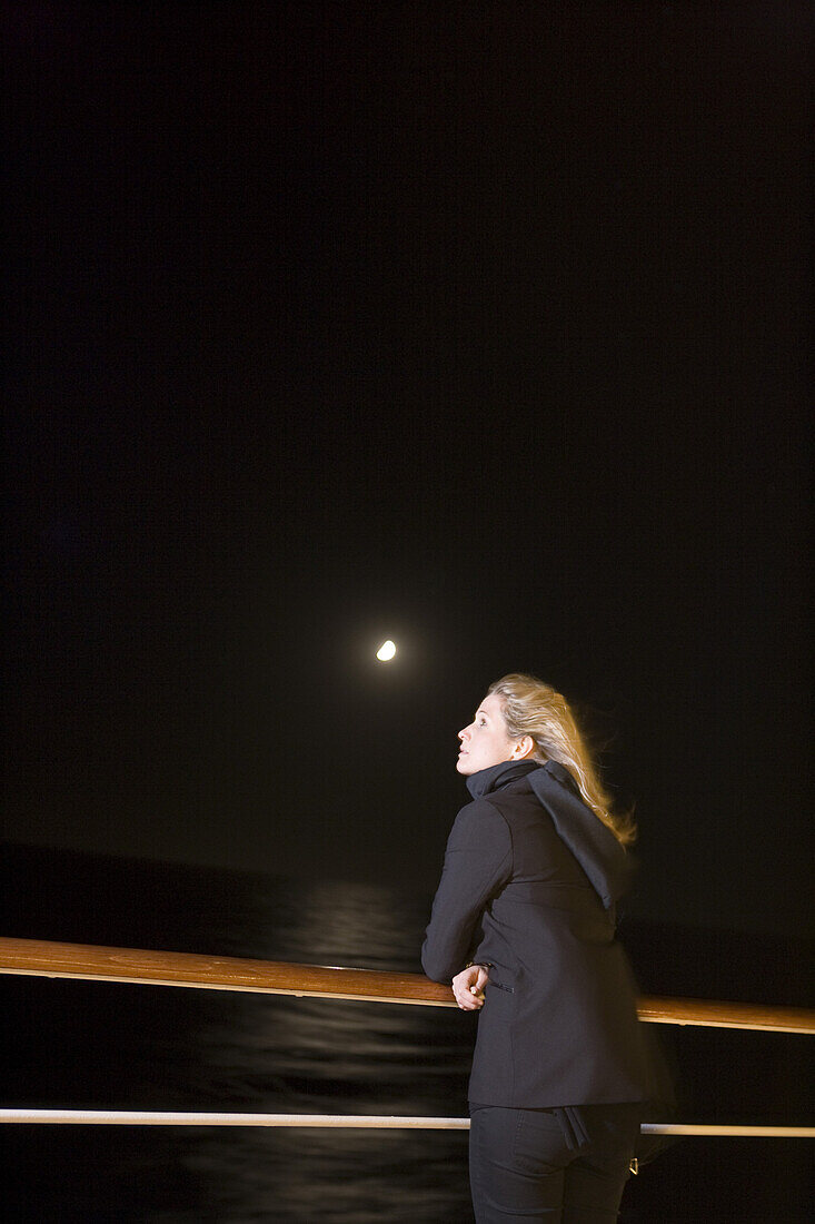 Woman at railing of cruiseship MS Deutschland (Deilmann Cruises) at full moon, South Atlantic Ocean, South America, America
