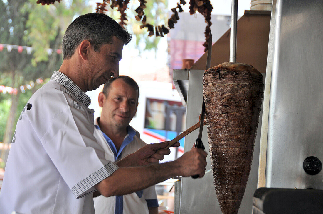 Mann schneidet mit dem Messer Dönerfleisch ab,  Manavgat, Südküste, Türkei