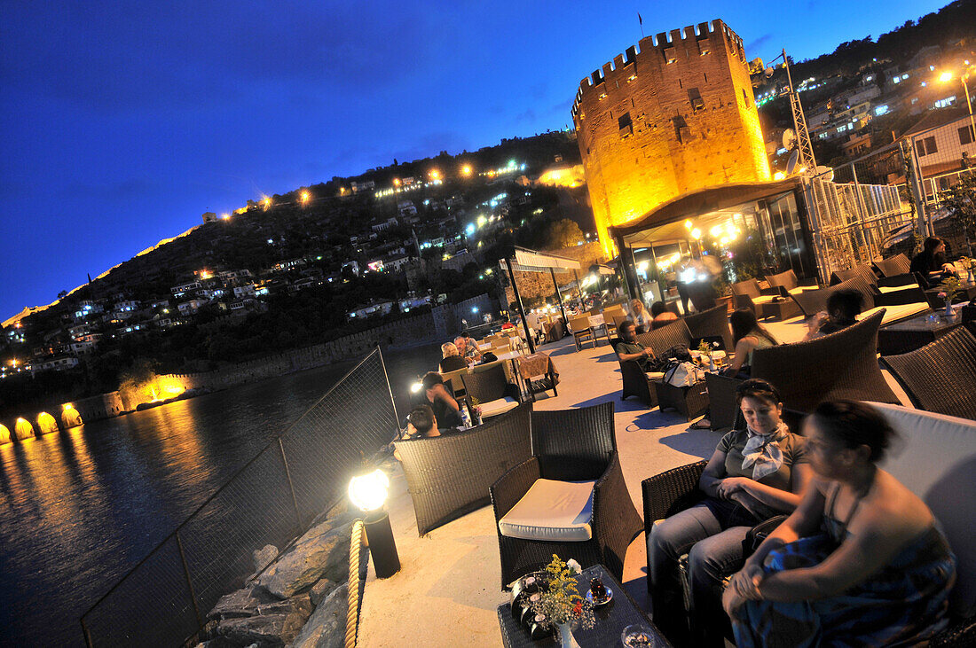 Cafe near the tower of Kizil Kule in the harbourin the evening, Alanya, south coast, Anatolia, Turkey