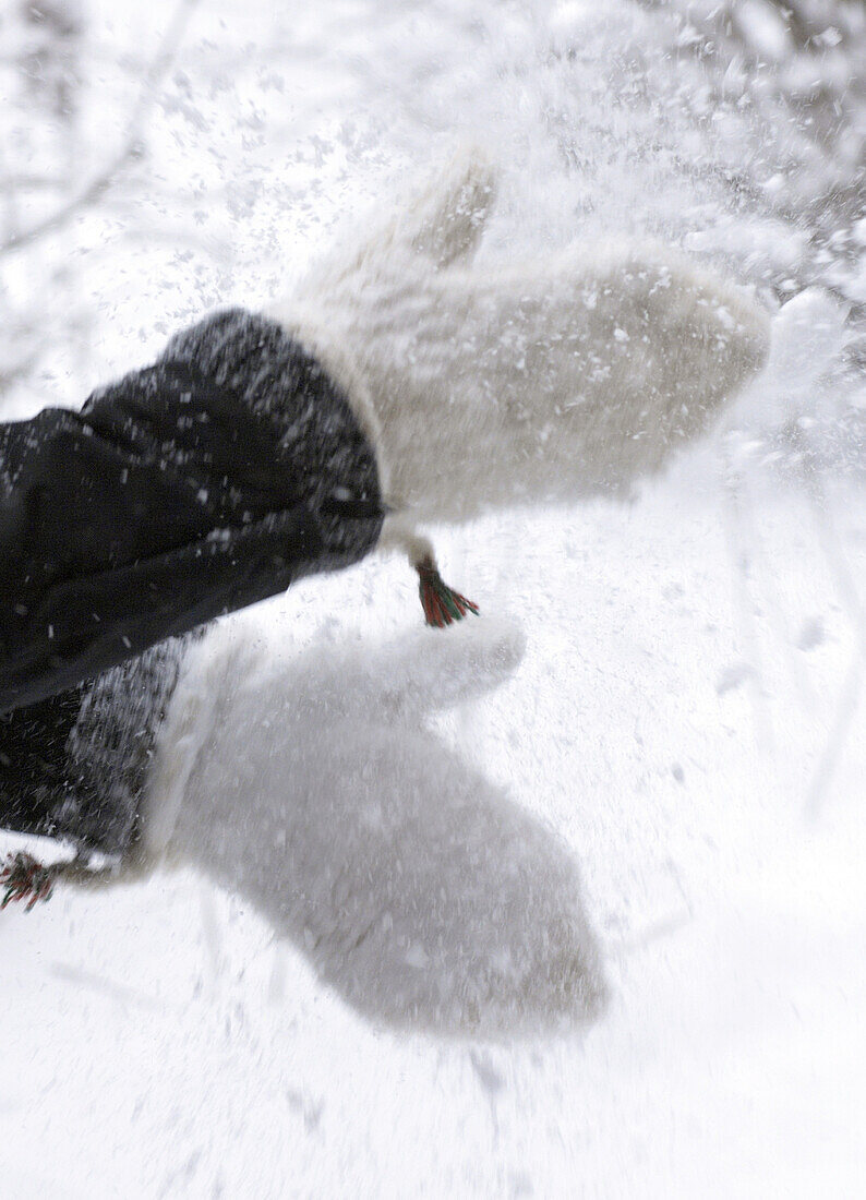 Händ eines Kindes mit schneebedeckter Fäustlinge im Winter