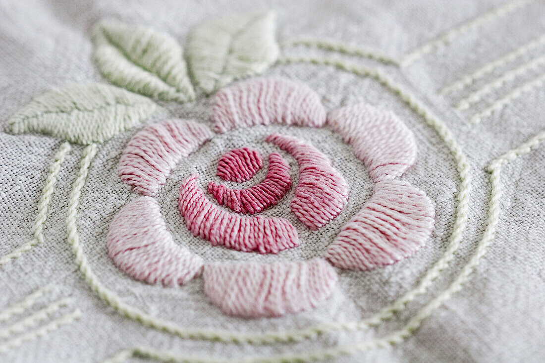 Pink embroidered flower on a piece of cloth