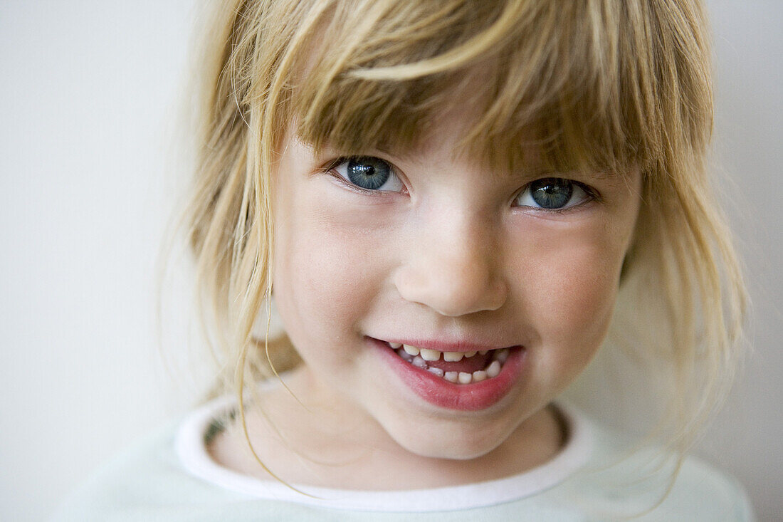 Close up of a blond little girl with fringe naive eyes and open mouth