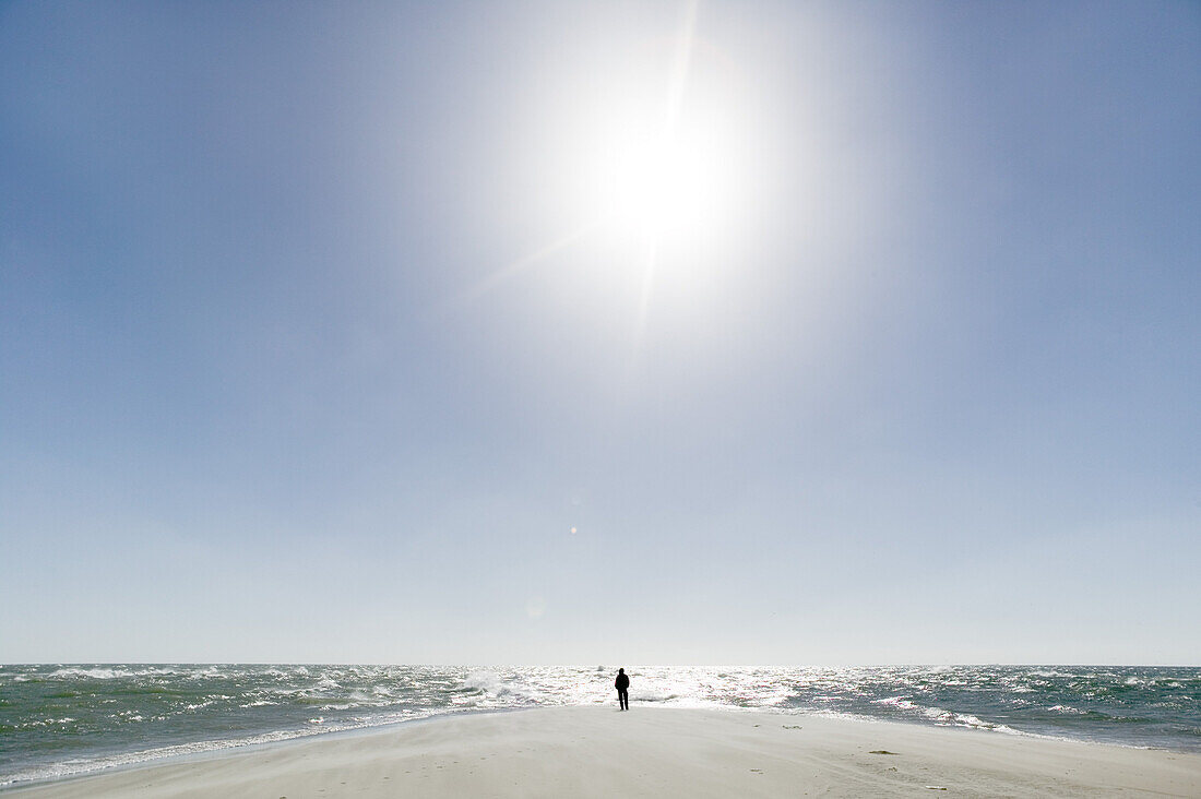 Man stands on a beach, the farthest headland where Skagerrak and the Kattegatt meet, Skagen, Jutland, Denmark