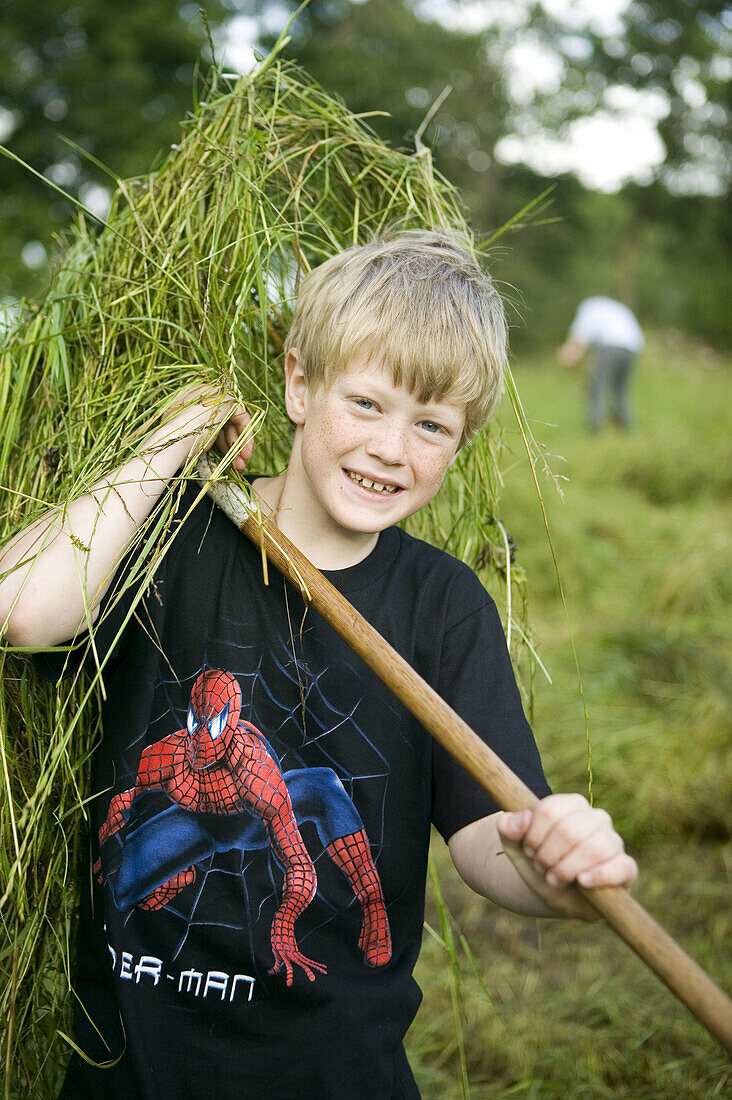 Boy with rake on a field