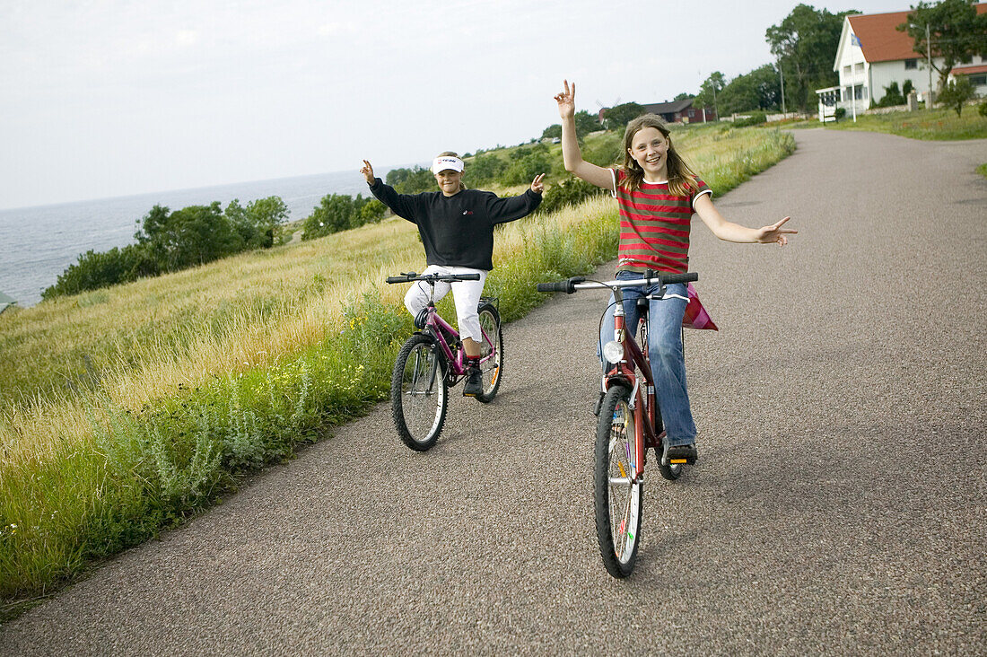 Two girls riding bikes, (MR)