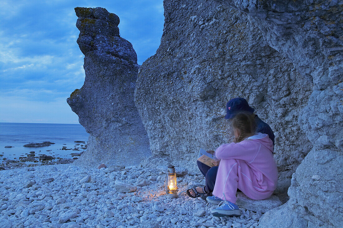 Mother and daughter on beach with sea stacks