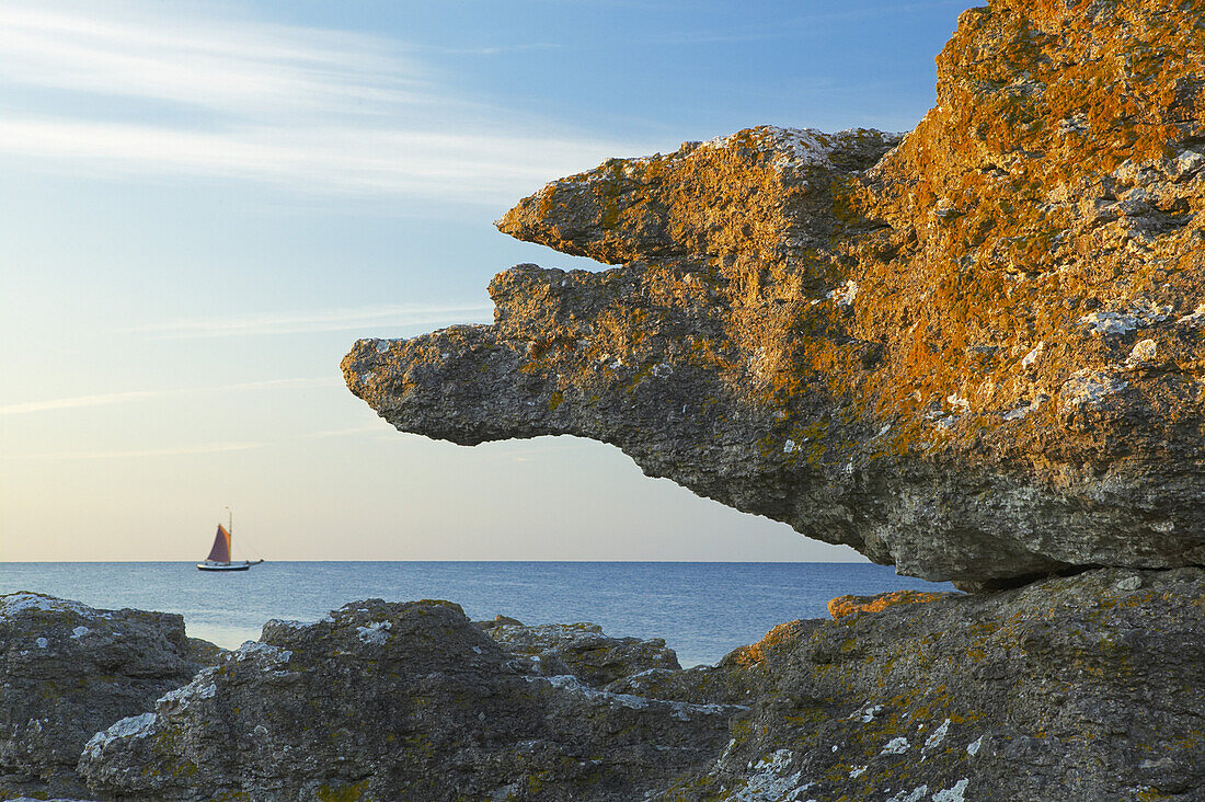 Sea stack with sailingboat in background