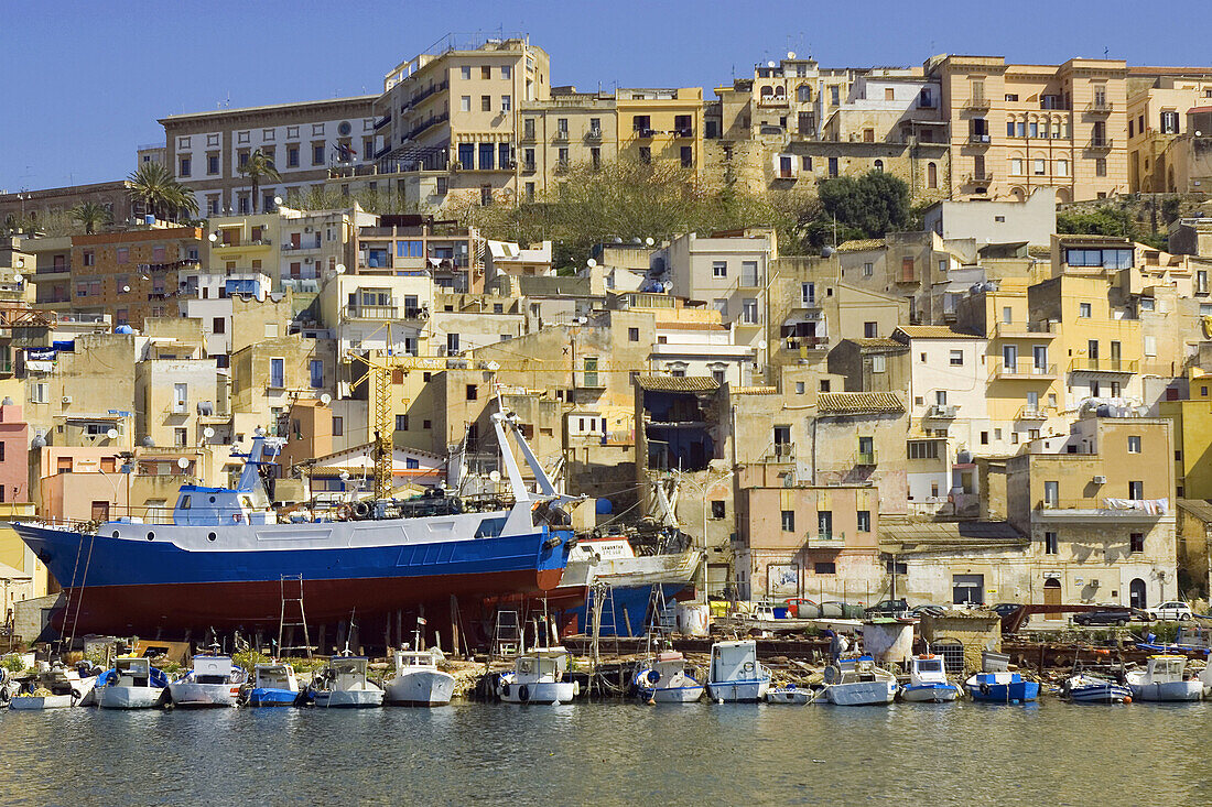 Fishing boats in harbor town in background Sciacca Sicily Italy Europe