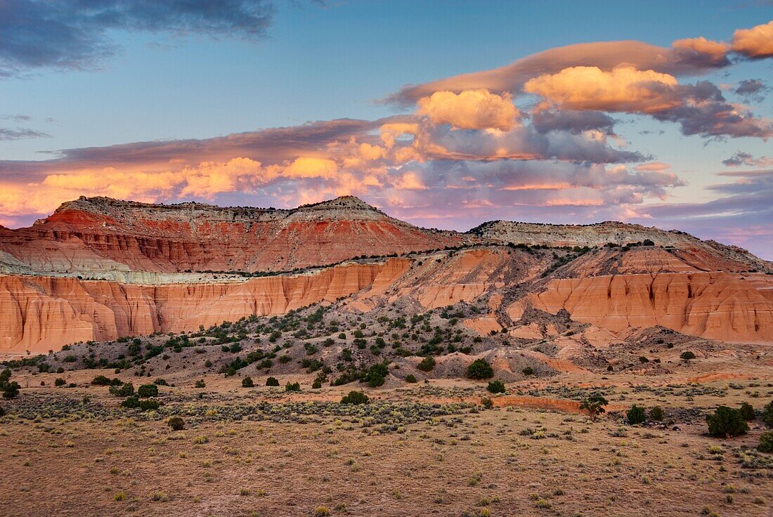 Clouds above mesas glowing in the light of setting sun, Upper Cathedral Valley at sunset, Capitol Reef National Park Utah