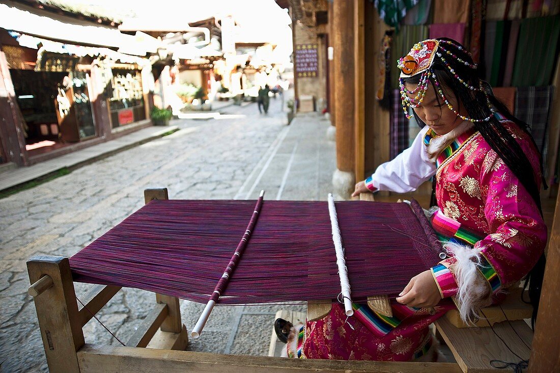 Mujer tejiendo traje tradicional