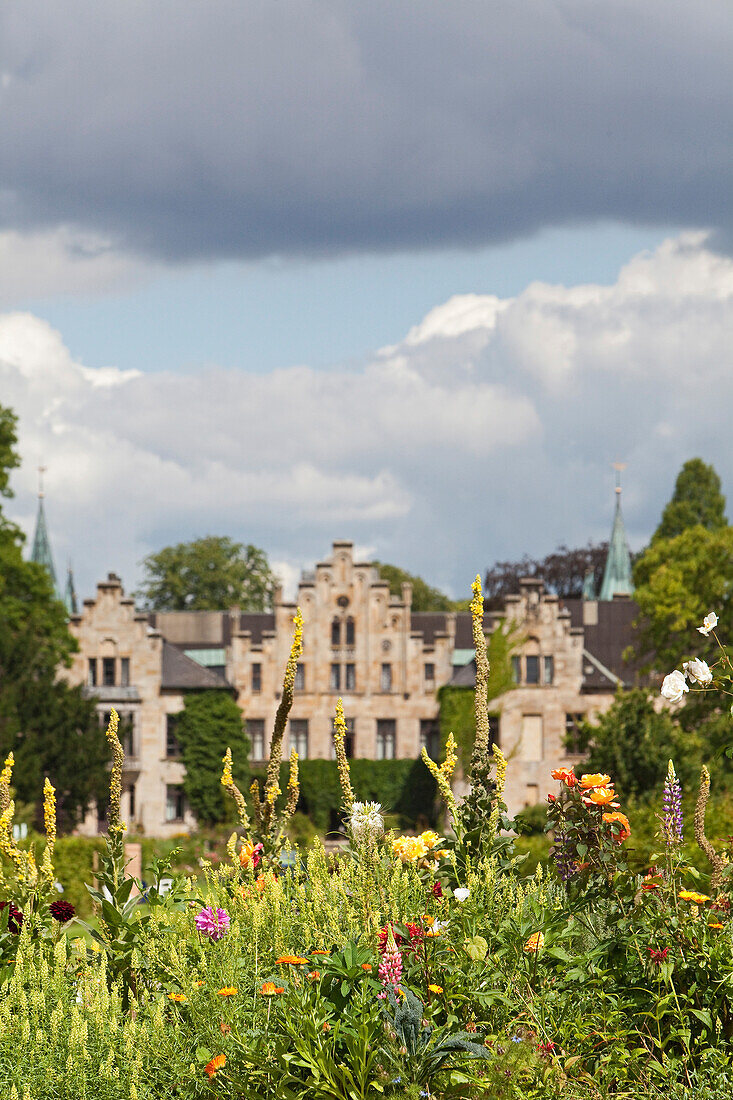 Schloss Ippenburg, Blick aus dem Garten durch Sträucher und Blumen, Bad Essen, Niedersachsen, Deutschland