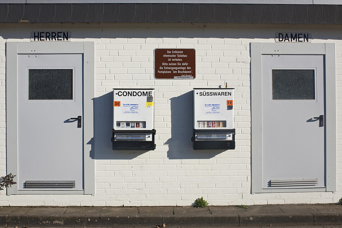 Sweets and condom vending machines on the wall of a toilet block, Steinhude, Lower Saxony, Germany