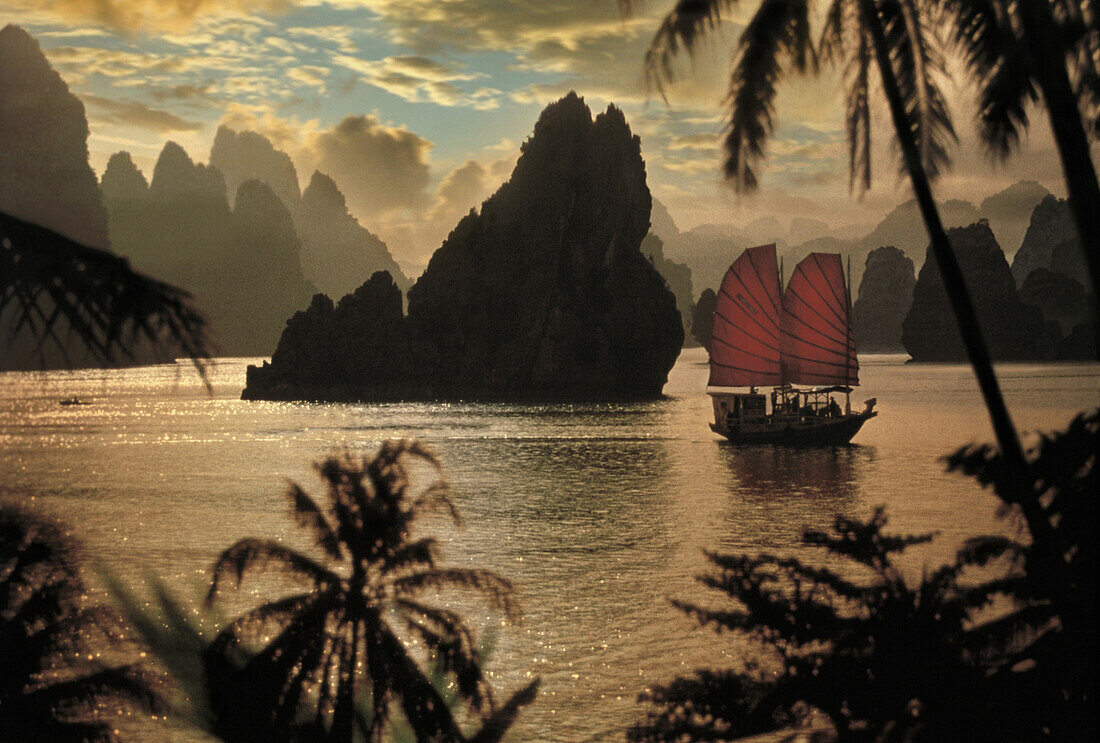 Junk in front of limestone formation at sunset, Halong Bay, Vietnam, Asia