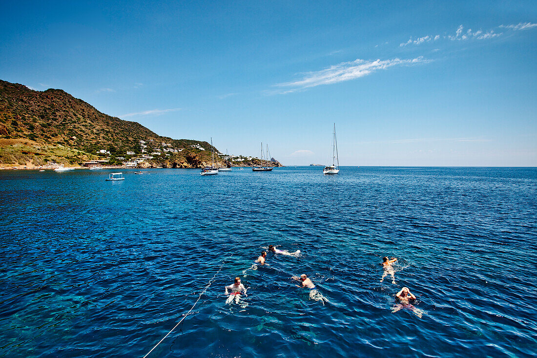 Badende Menschen in einer Bucht vor Panarea, Liparische Inseln, Sizilien, Italien