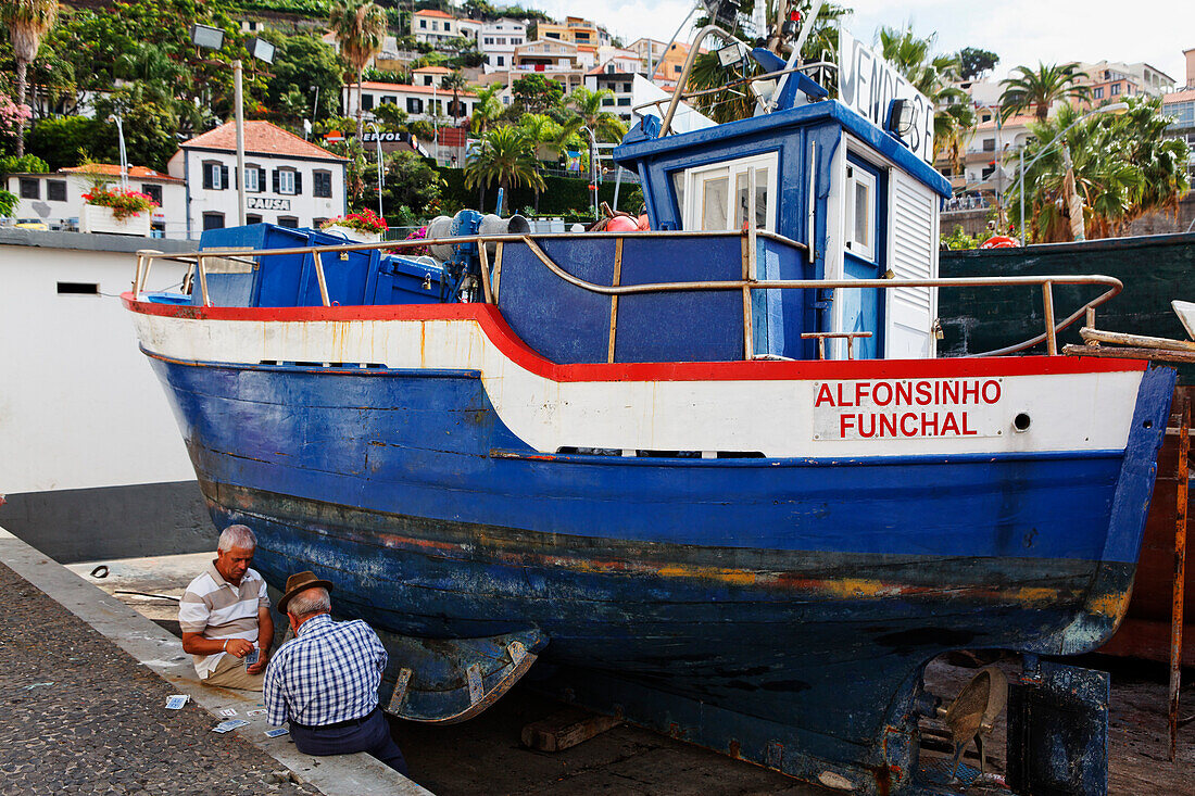 Männer beim Kartenspielen im Hafen von Camara de Lobos, Madeira, Portugal