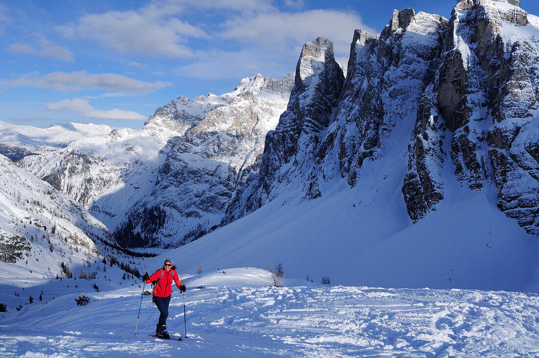 Woman backcountry skiing ascending to Sextener Stein, Sextener Dolomites range in background, Sexten, UNESCO World Heritage Site, Dolomites, South Tyrol, Italy