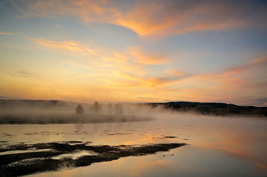 Pre-dawn skies reflected in the Yellowstone River with morning fog