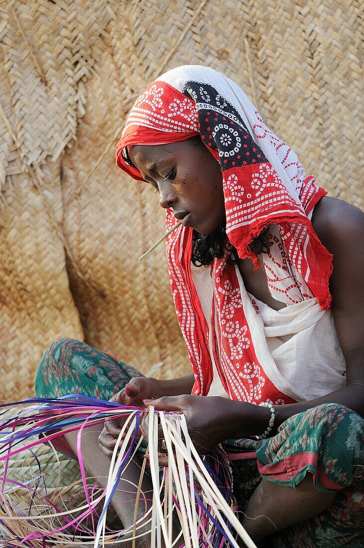 Ethiopia, Afar region, Ahmedila village, Young Afar woman weaving a mat