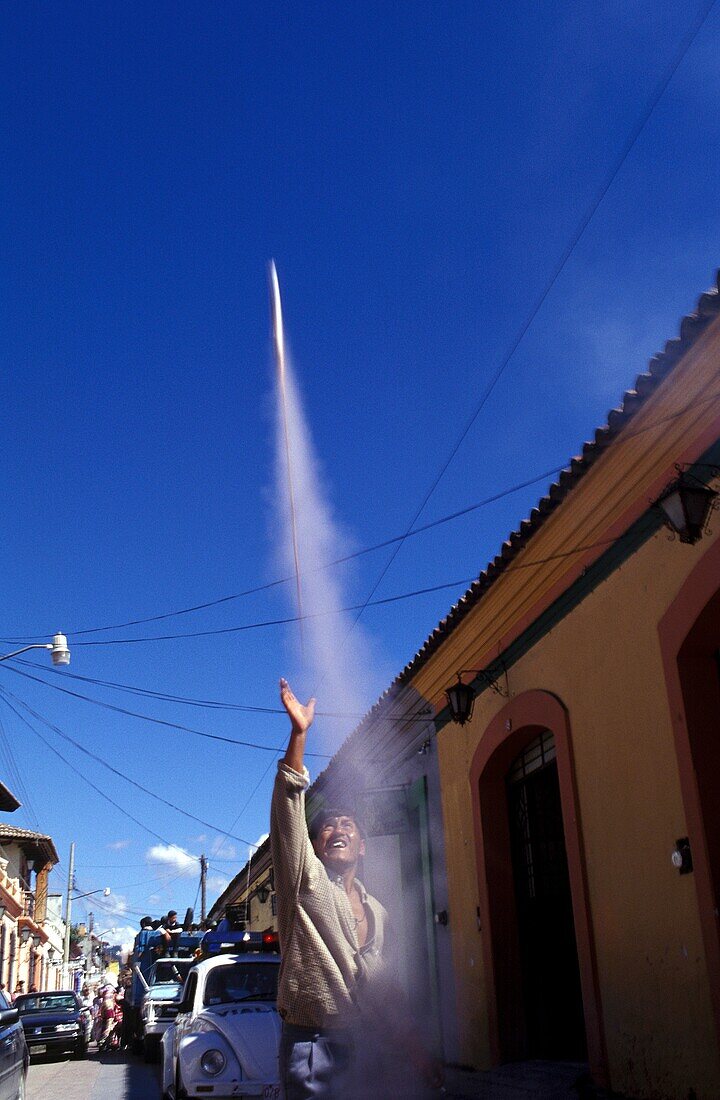 Man releasing fireworks in the street during a parade in San Cristobal de las Casa, Chiapas, Mexico