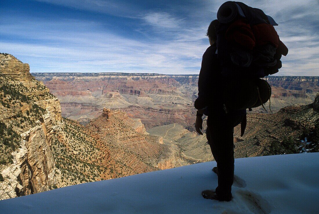 Grand Canyon National Park - Martha Gruelle backpacking in snow near the top of the Bright Angel Trail in the Grand Canyon  Temperatures can be as much as 30 degrees F warmer at the bottom of the canyon  MR Copyright © Jim West