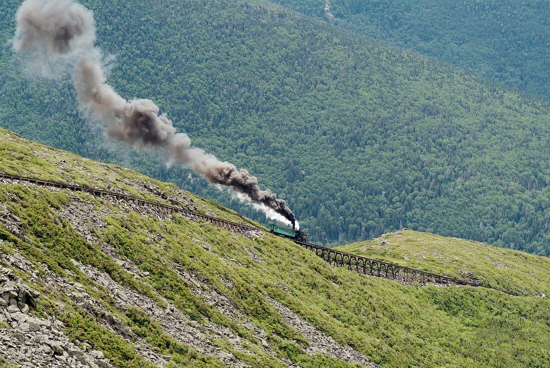 The Mount Washington Cog Railroad heading up Mount Washington during the summer months in the scenic landscape of the White Mountains, New Hampshire USA  Notes: