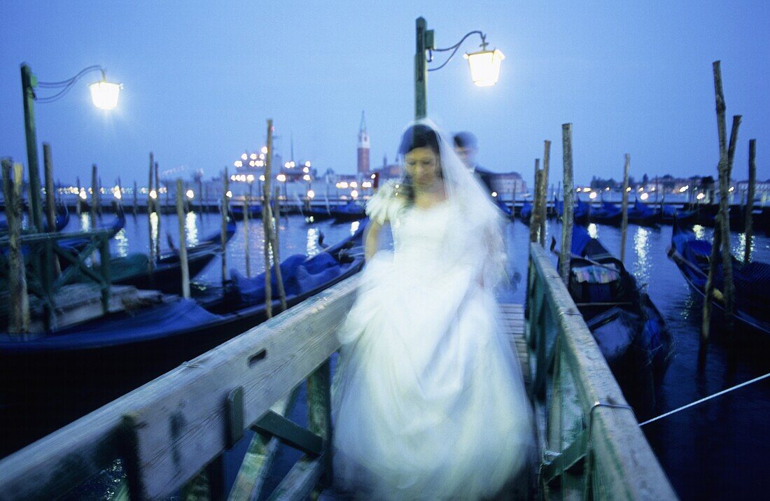 Bride and groom with gondolas at San Marco Pier and San Giorgio Maggiore in background  Venice  Veneto, Italy