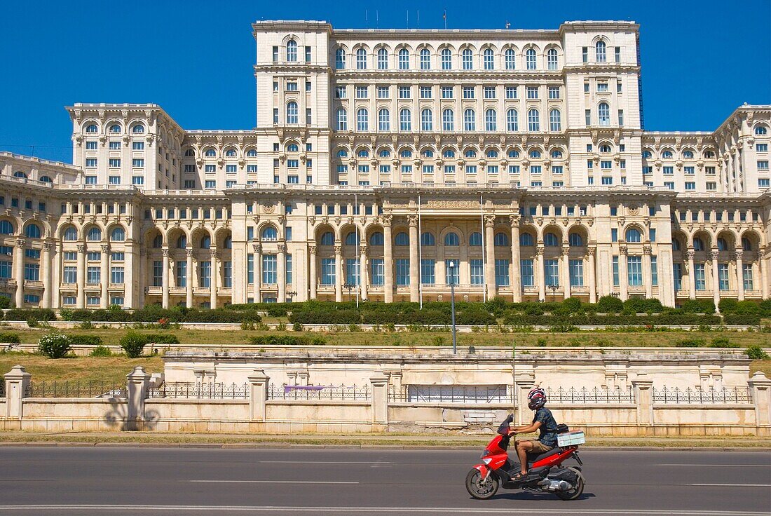 Scooter passing Palace of Parliament building in Bucharest Romania Europe