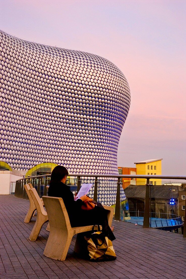 Woman reading outside Selfridges department store Bullring shopping centre Birmingham England UK Europe