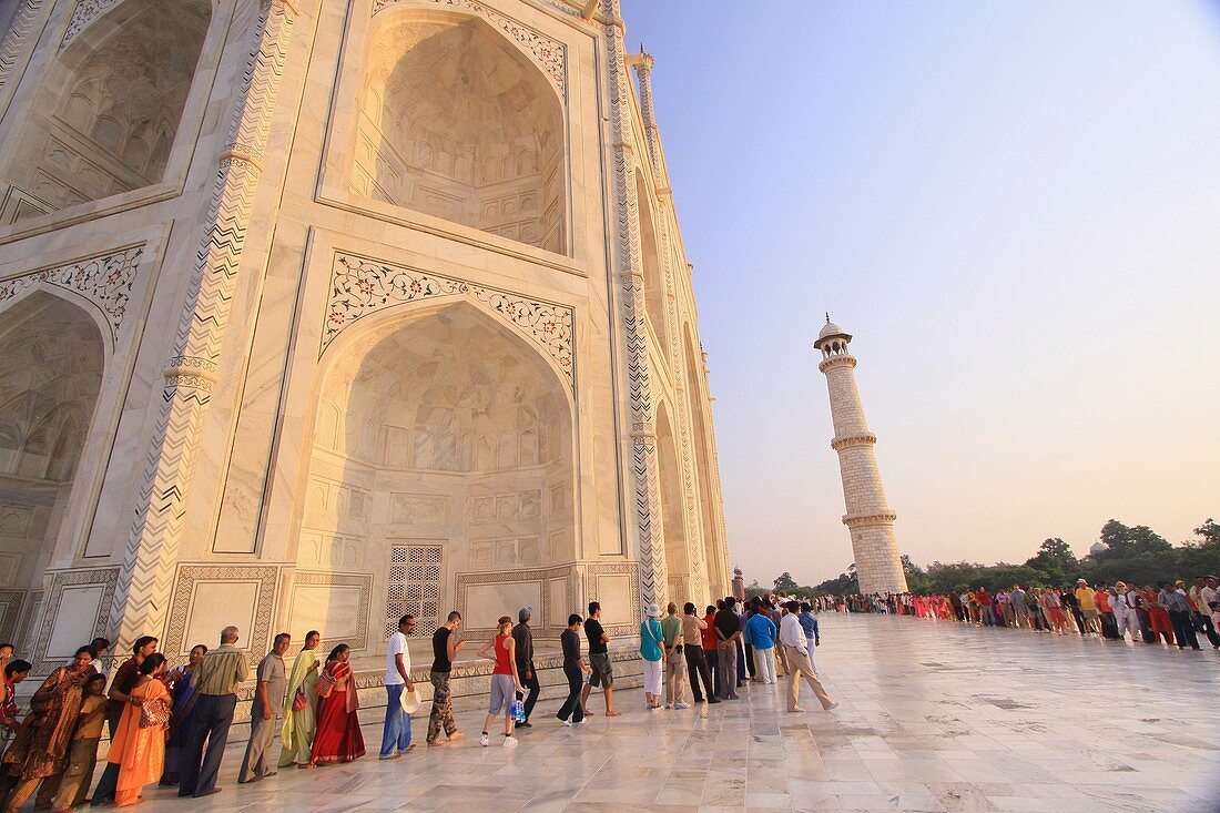 Tourists wait in line on the marble floor to enter the inside of the Taj Mahal, Agra, India