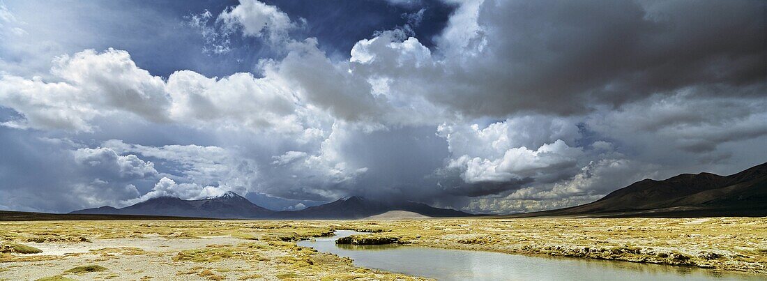Salar de Surire app 4300m and the thermas de Poloquere, Chile  During the rainy season or Bolivian Winter, daily thunderstorm are building up huge clouds bringing rain or hail  The salt lake Salar de Surire is part of the Biosphere Reserve Lauca, The whol