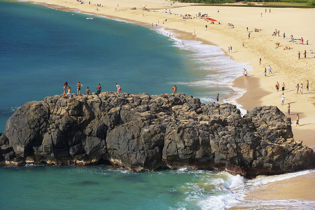 People on a rock at the beach, Weimea Bay Beach Park, North Shore, Oahu, Hawaii, USA, America
