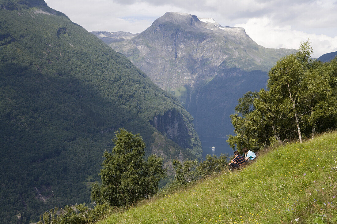 Paar blickt von Bergalm über den Geirangerfjord, Geiranger, More og Romsdal, Norwegen, Europa
