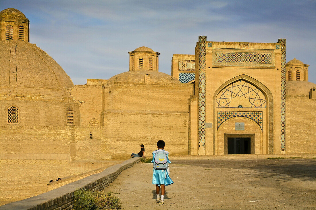 Girl walking towards Mir-i Arab madrassa, Bukhara, Uzbekistan