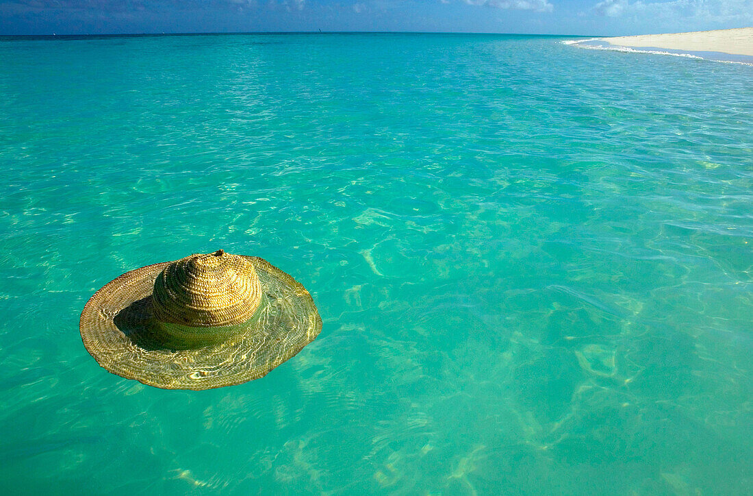 Tanzania. Mnemba Island. Lost hat floating in the clear waters of the Indian Ocean
