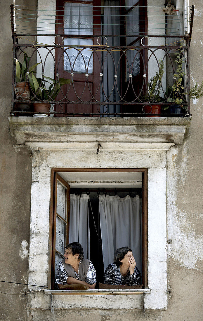 Two women look from a window in Porto Oporto in northern Portugal