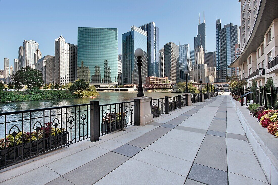 Sidewalk along Chicago River with skyline beyond