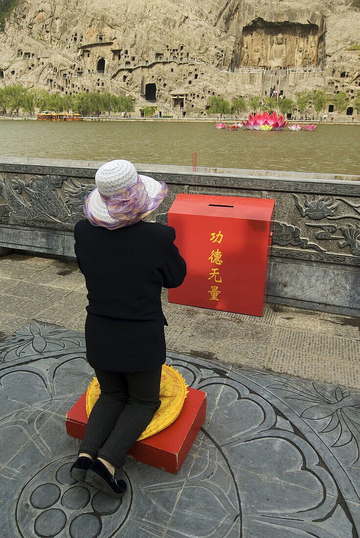 China, Henan province, Longmen grottos, praying woman