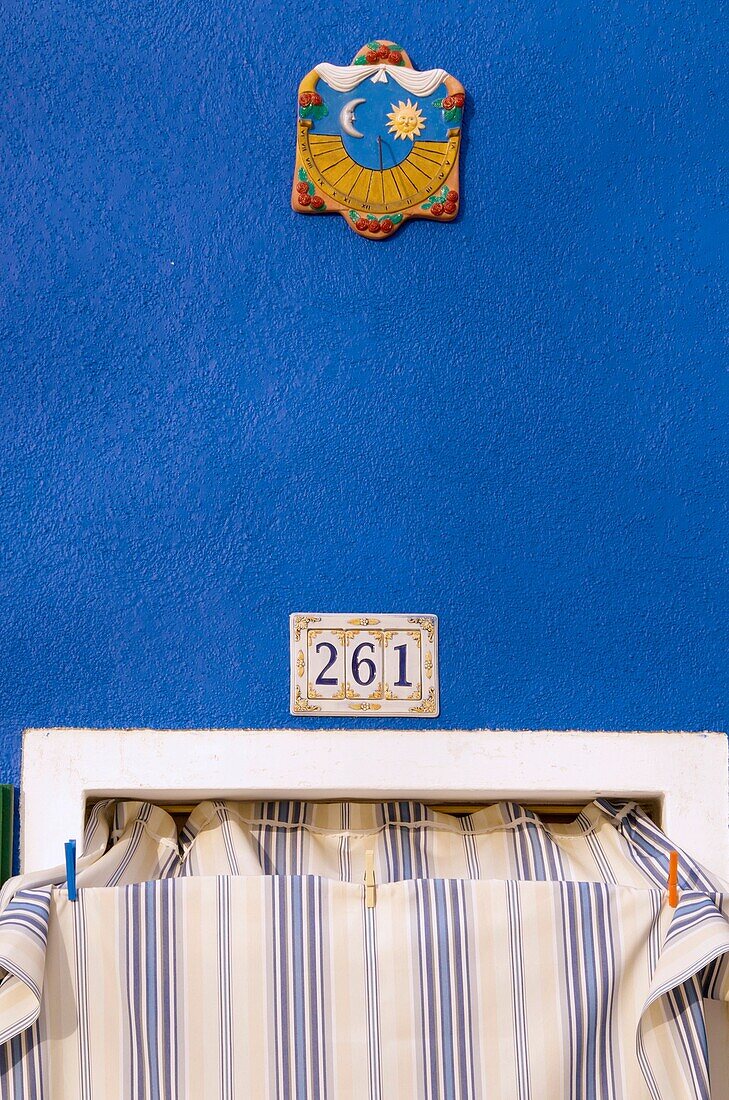 house number and door detail above awning, in street, Burano island, Venice, Italy