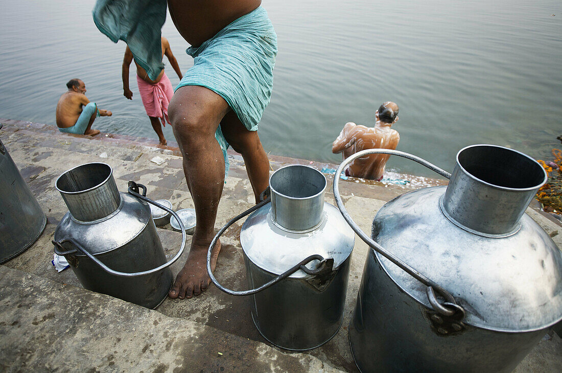 Milk cans on the ghats of Ganges river, Varanasi. Uttar Pradesh, India