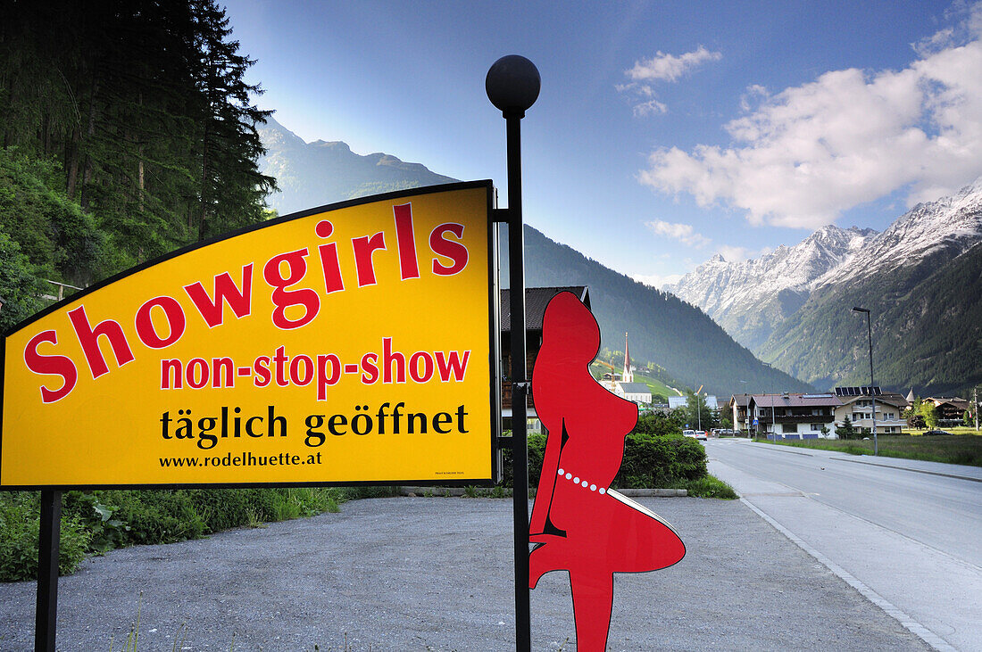 Illuminated advertising for a night show with village and mountains in the background, Soelden, Oetztal valley, Tyrol, Austria