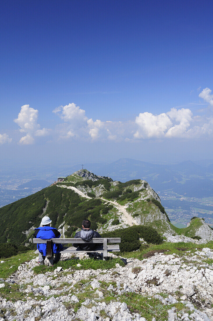 Zwei Wanderer sitzen auf Bank und blicken zum Geiereck, Salzburger Hochthron, Untersberg, Berchtesgadener Alpen, Berchtesgaden, Oberbayern, Bayern, Deutschland